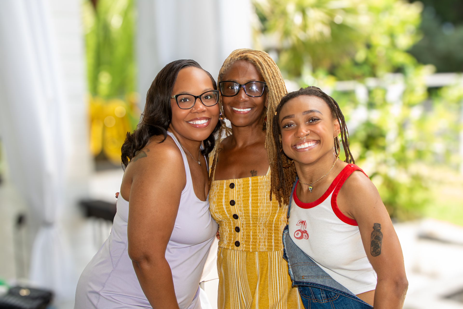 Three women smiling together on the porch