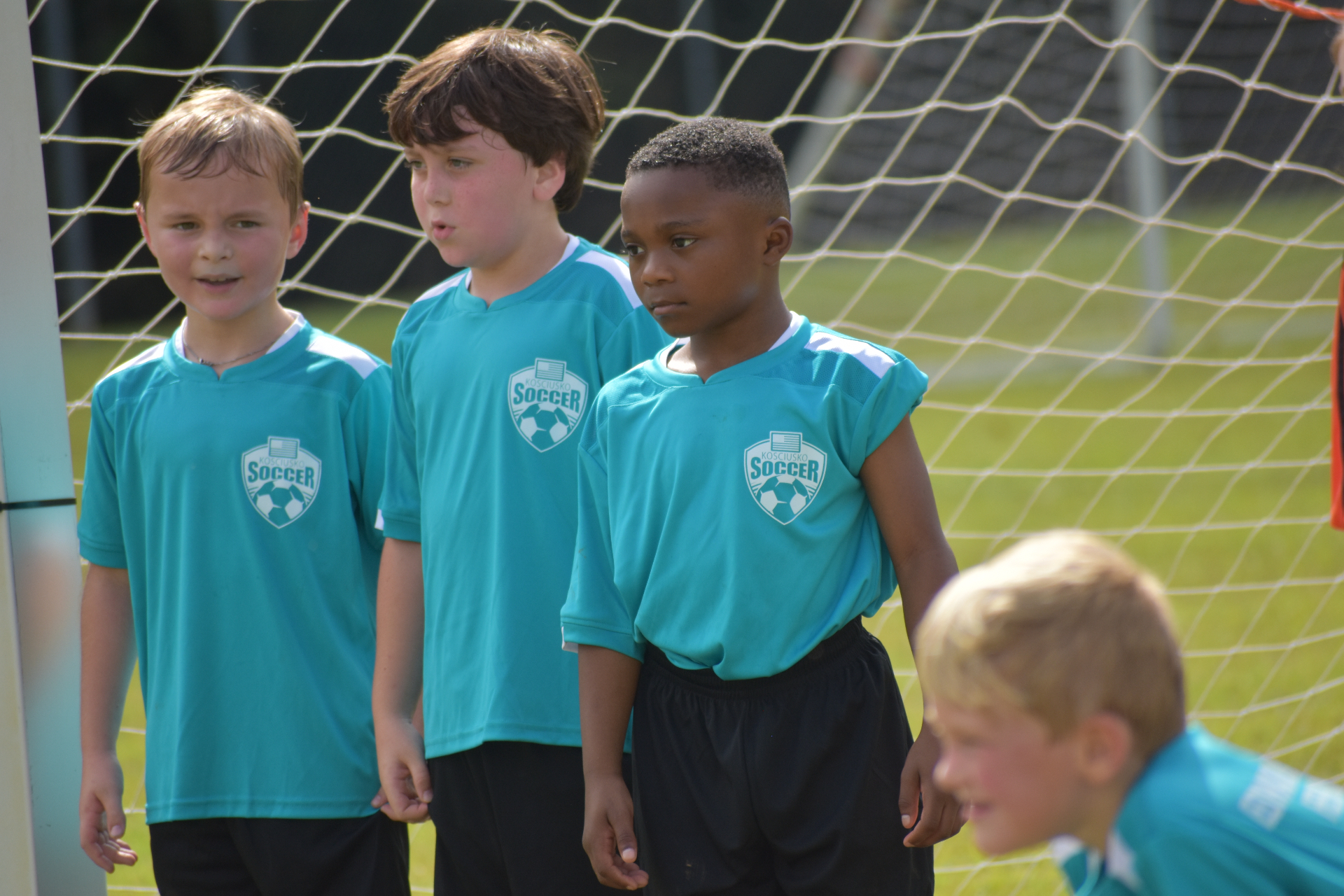 Four teammates in teal