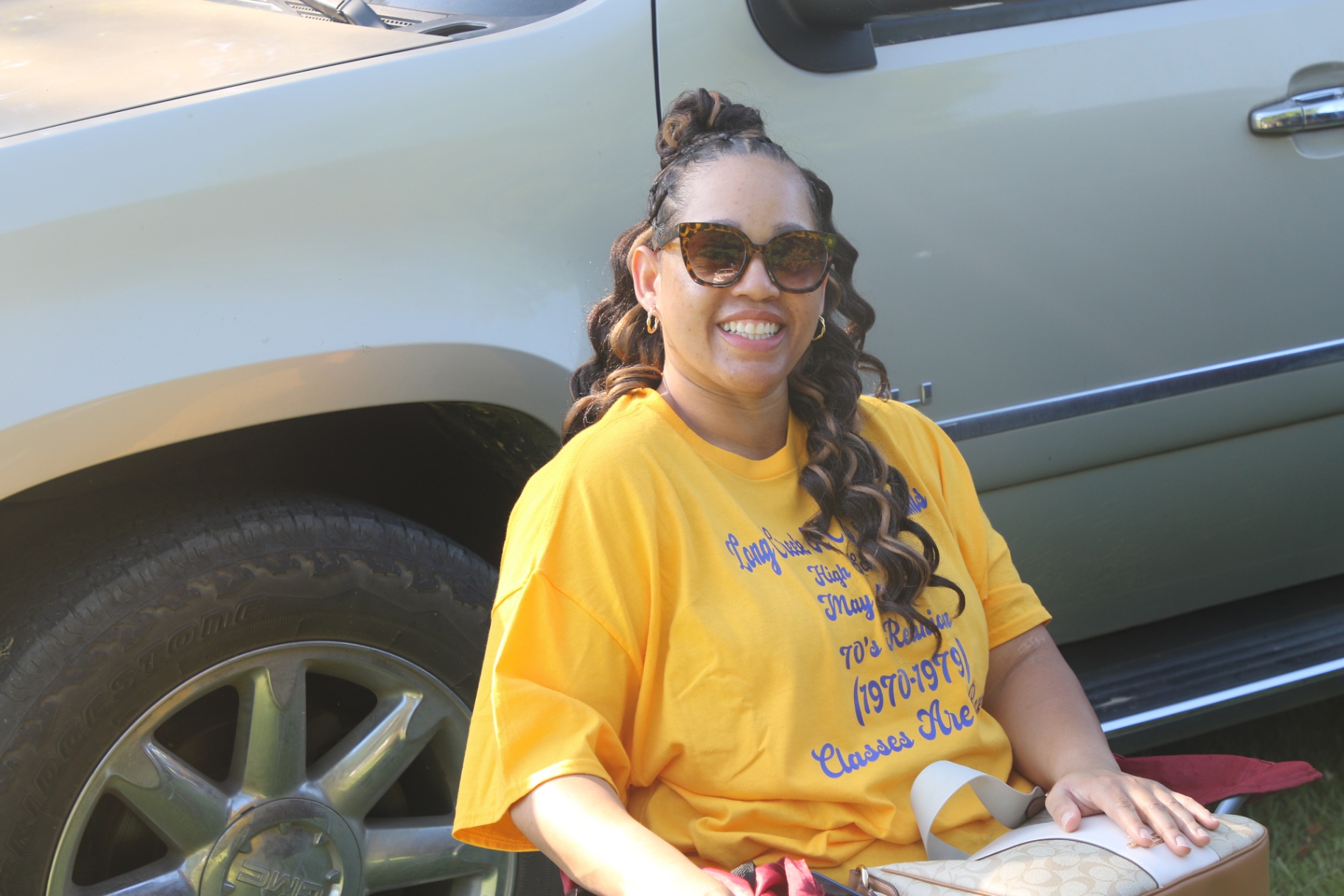 Classmate resting by the SUV in the reunion gold tee